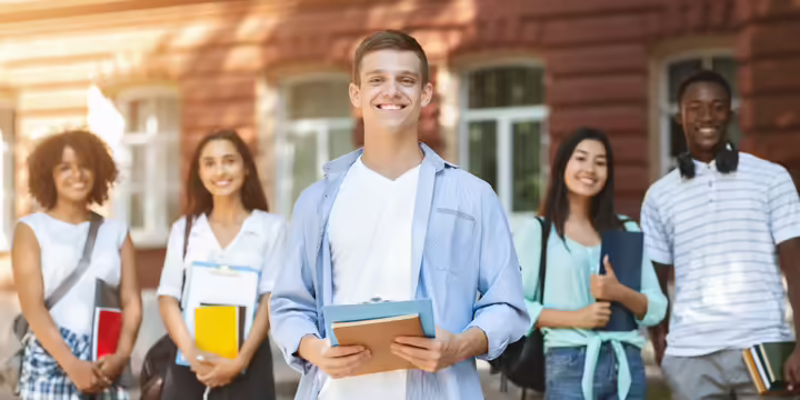 five teens standing in a row smiling at the camera