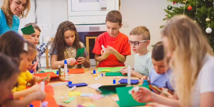 A group of kids working with glue and paper making crafts