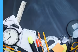 notepads, pencils, ruler, scissors, protractor, magnifying glass on a desk