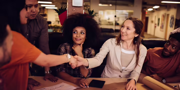 person shaking hands across table