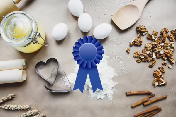 Baking supplies and ingredients with a graphic of a blue ribbon over the top of the picture. 
