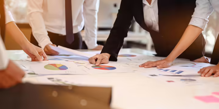Group of individuals using charts and sticky notes to plan