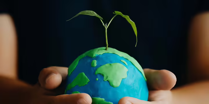 hands holding a clay earth