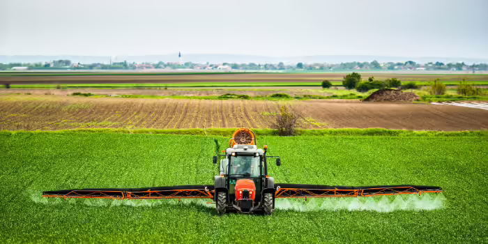 A tractor applying pesticide to a field. 