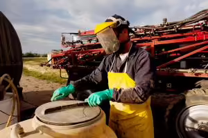 Filling a high clearance sprayer with chemical and water with proper safety equipment