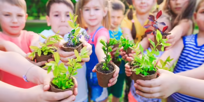 A group of kids holding plants 