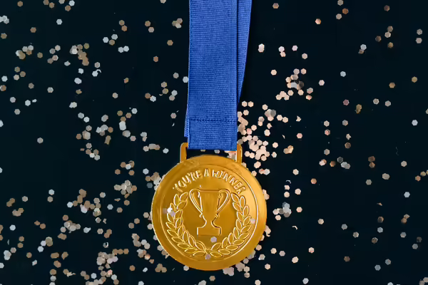 Picture of a gold medal in front of some glitter