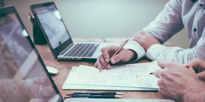 People looking at paperwork and laptops.