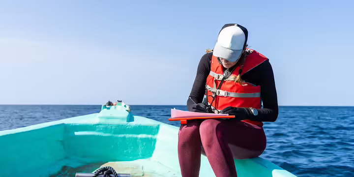 a woman in a boat takes notes