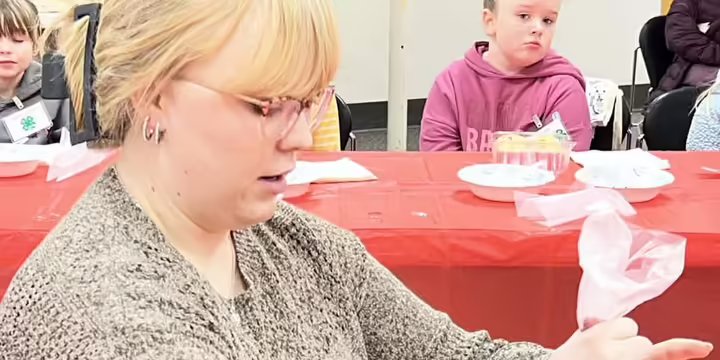 Young woman piping frosting on a cupcake