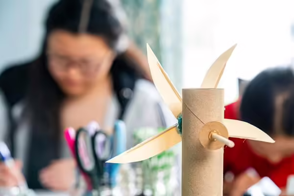 cardboard wind turbine project with 4-H member in the distant background