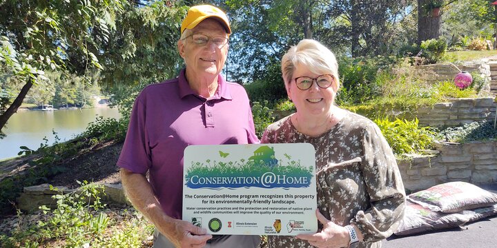 Mr and Mrs Coleman holding their Conservation at Home sign