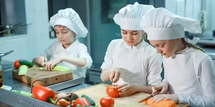 3 young children chopping vegetables 