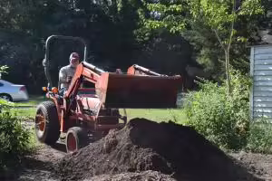 man on a tractor with scoop bucket
