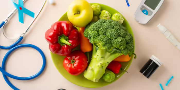 Bowl of fresh vegetables with a glucose meter, insulin supplies, and a stethoscope, representing healthy eating and diabetes care.