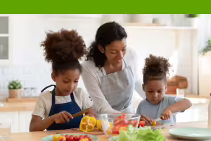 mom and daughters preparing a salad