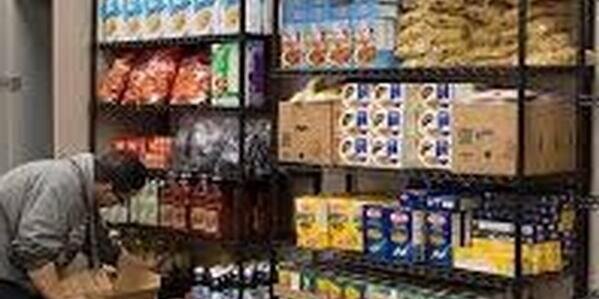 person stocking food pantry shelves
