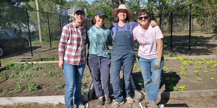 four ladies standing in a garden