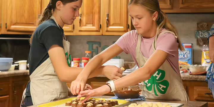 4-Hers dip candy in chocolate as part of workshop.
