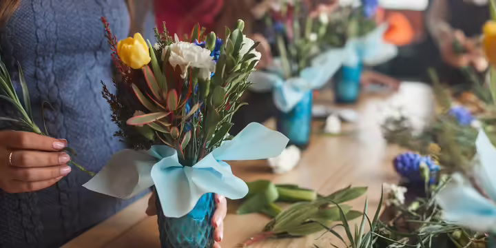 woman adding flowers to a bouquet