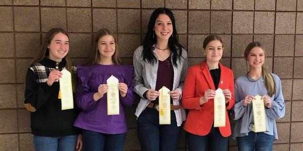 4-H youth lined up holding their ribbons from 2023 Horse Bowl competition. 