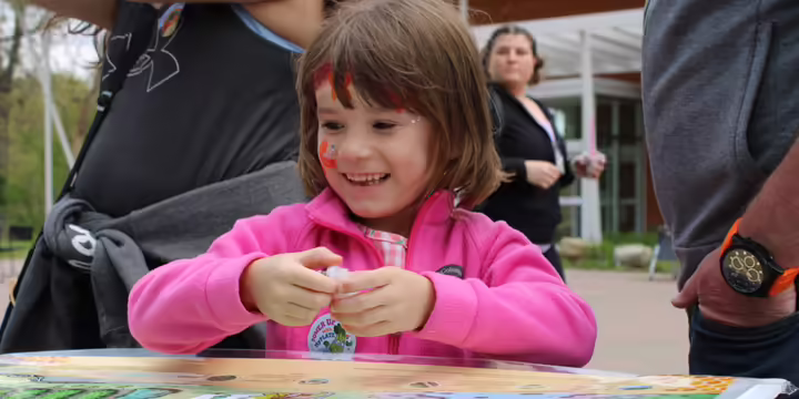 child smiling looking down at a map