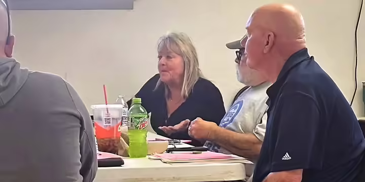 People sitting around a table with one person speaking