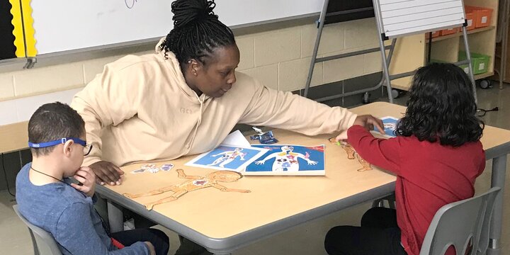 Teacher helps students with project