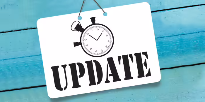 A white sign displaying the word “UPDATE” in bold black letters beneath a stopwatch illustration.