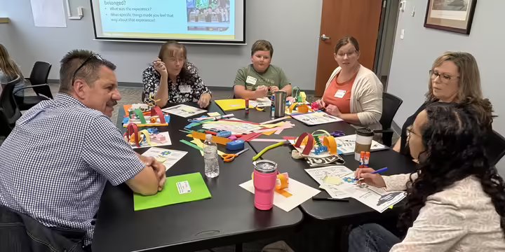 People talking to each other while sitting around a table