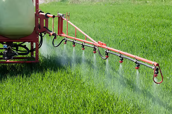 Tractor applying pesticide in field