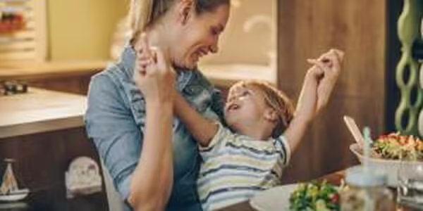 Mother and son at dinner table.