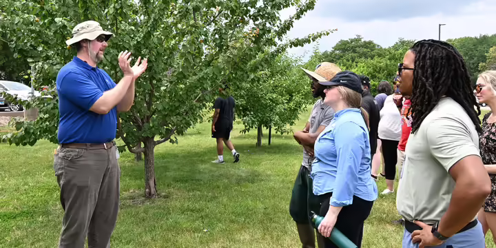 Dr. John Fisher teaching in an orchard