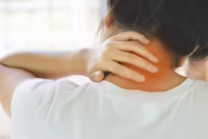 Woman holding her hand on back of painful, tight neck