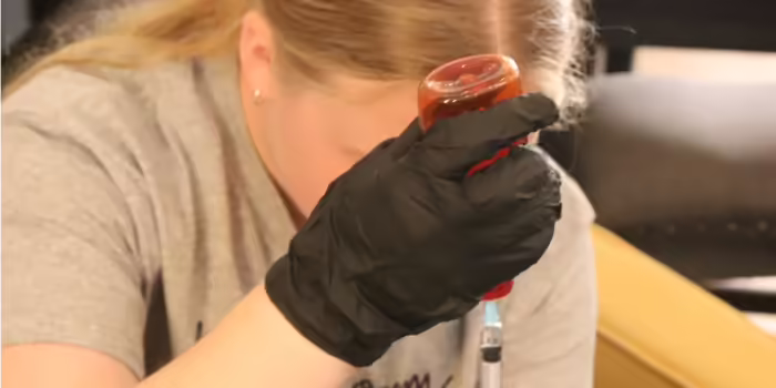 A teen girl practices how to give innoculations during vet camp.