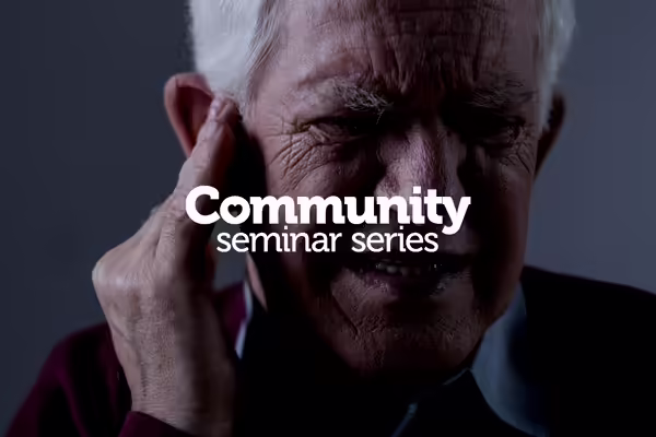 older man holding his ear