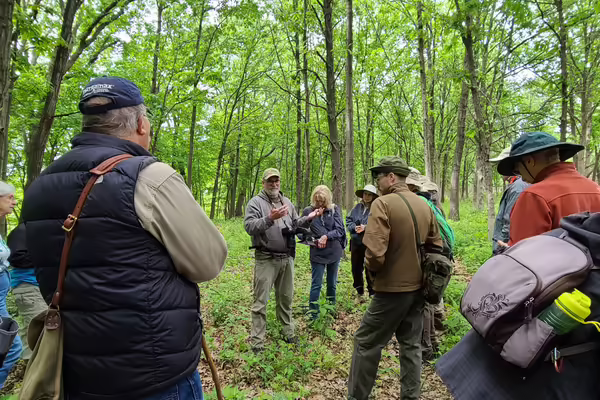 Man speaks to hikers in the woods