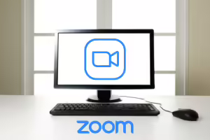 PC monitor on desk with Zoom icon and Zoom logo