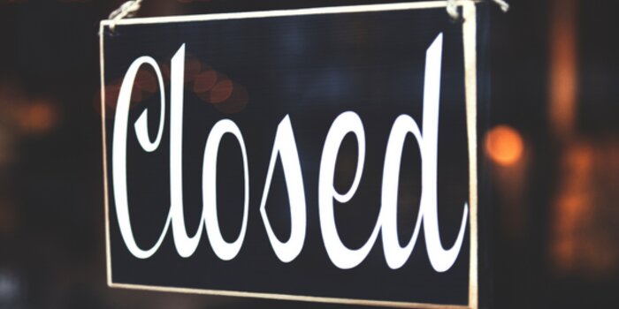 A closed sign on a blurred background.