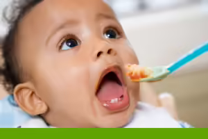 baby being feed food by a spoon