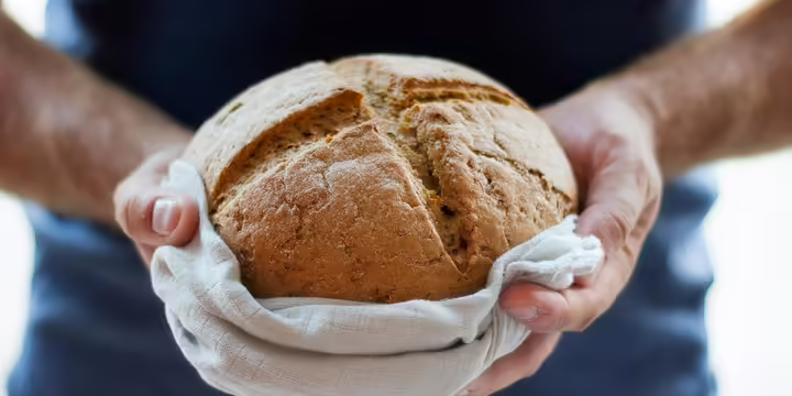 someone holding a loaf of homemade bread