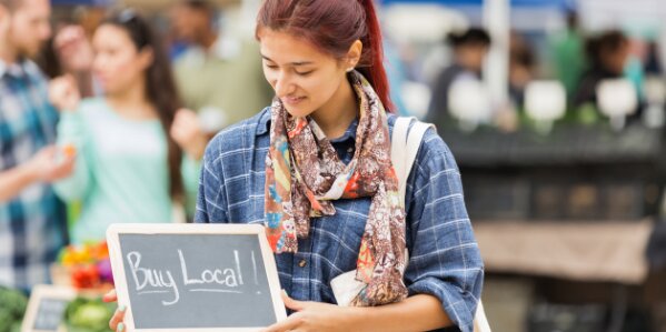 Young woman holding a buy local sign