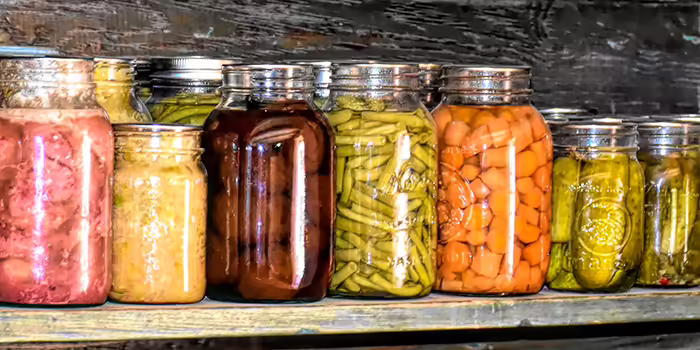 row of glass jars with vegetables