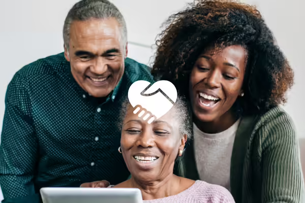 Three adults looking at a screen smiling