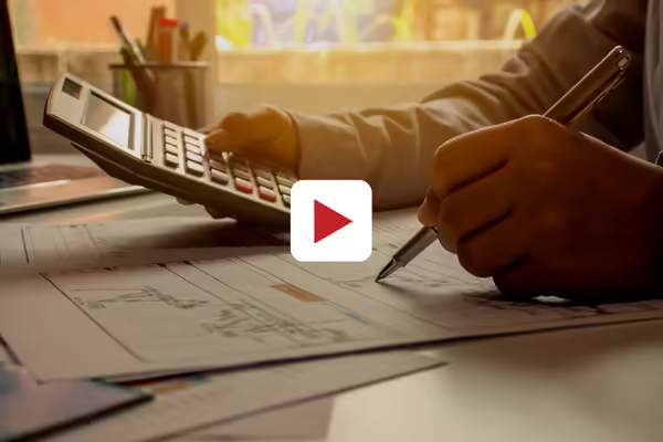 person with pencil and papers and calculator