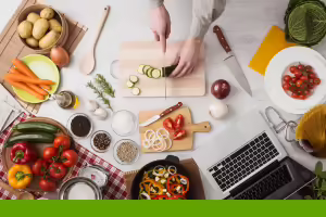 preparing food looking at a laptop screen