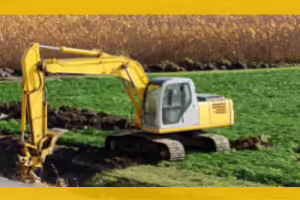 backhoe digging a trench in a field