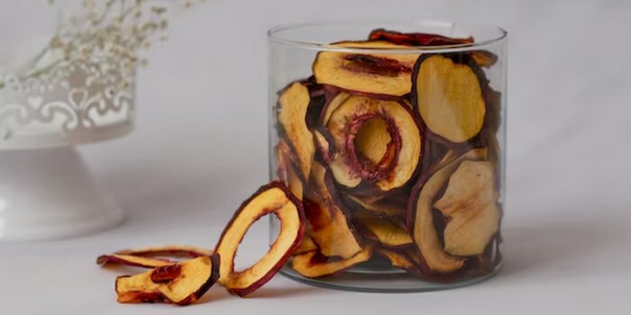 A clear container with dried peaches. 