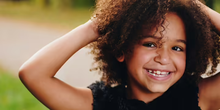 Smiling girl with hands on her head