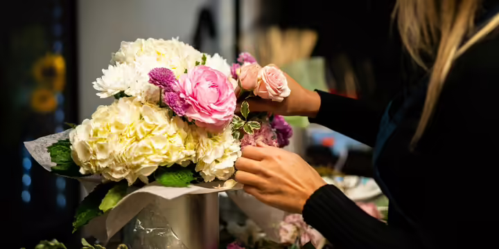 person arranging flowers in a vase